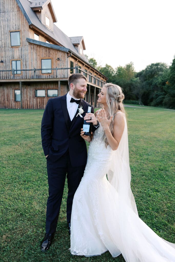 Bride and groom during their summer wedding at bear ridge in front of the burly bear barn